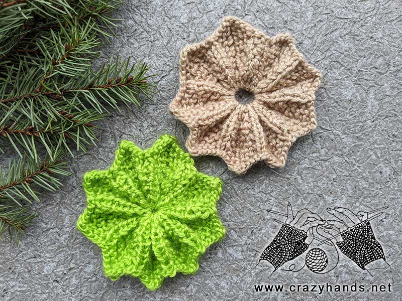 two knit wide and rounded flowers - one made in green and another one in light brown color