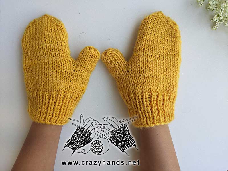 knit flat kid's mittens on girl's hands