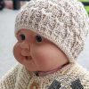 knit newborn baby hat on a doll mannequin - close-up view