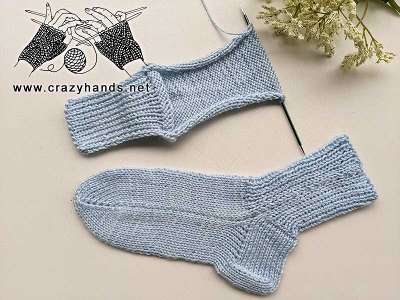 a pair of classic flat knit socks made with blue yarn