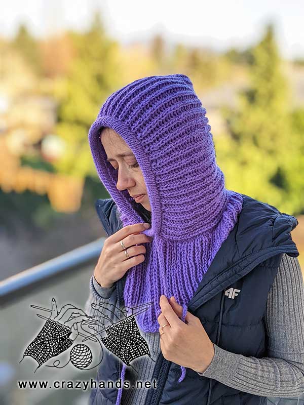 left side view of a knit ribbed hooded cowl on a female model