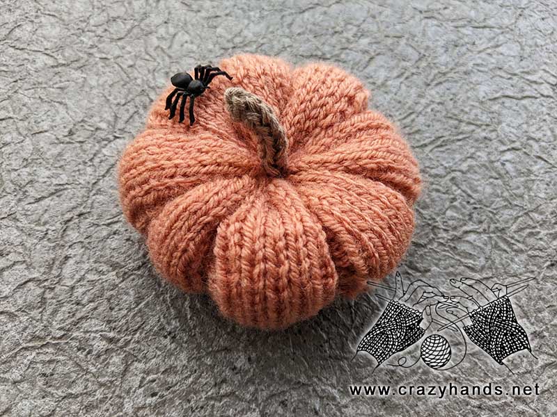 knit halloween pumpkin with a spooky spider on the top of it