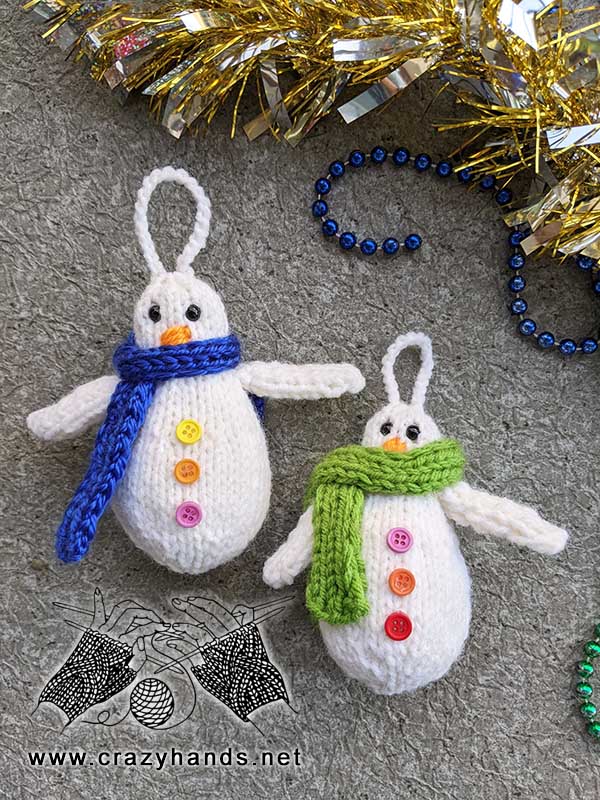 two knit snowmen decorated with scarves and buttons