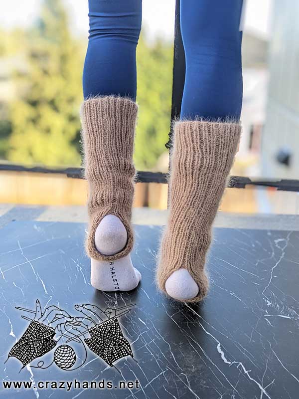 knit stirrup leg warmers on female's feet - back side view