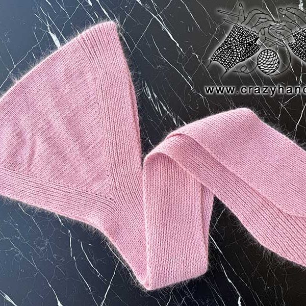 knit hat-hood with ties on the flat surface with dark background
