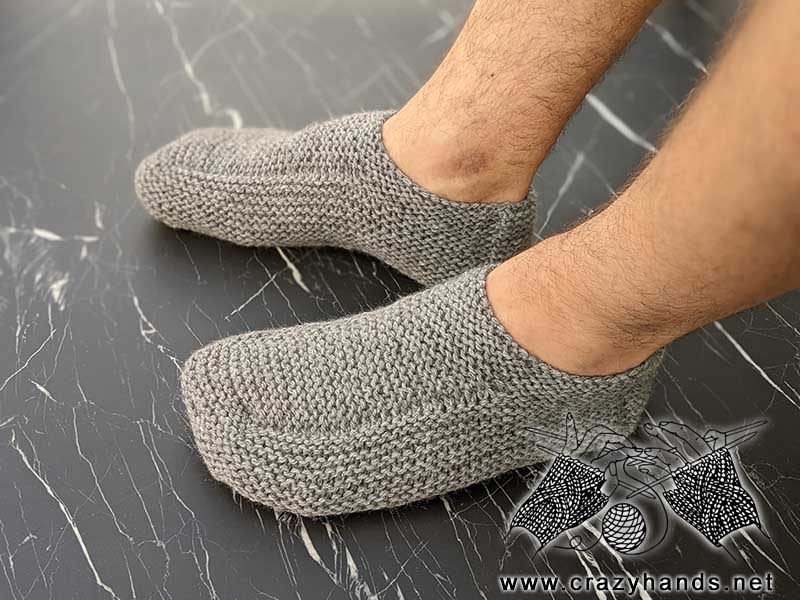 flat knit low-cut men's size slippers on the male's feet - left-side view